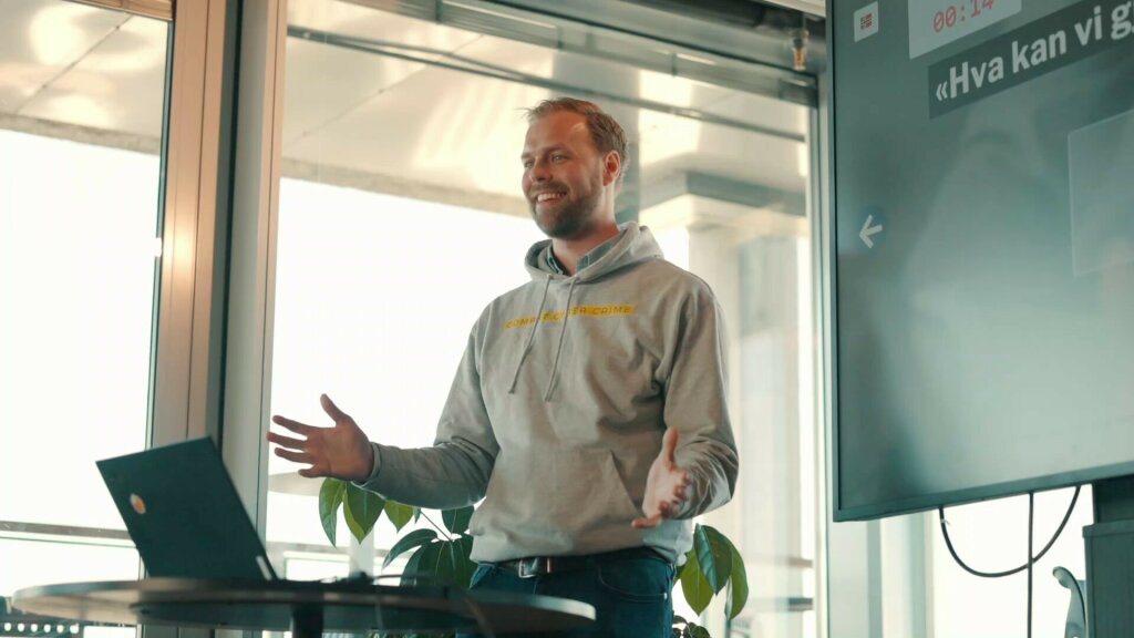 Secure Practice's co-founder Erlend Andreas Gjære on a stage during a PrepJam cybersecurity exercise.
